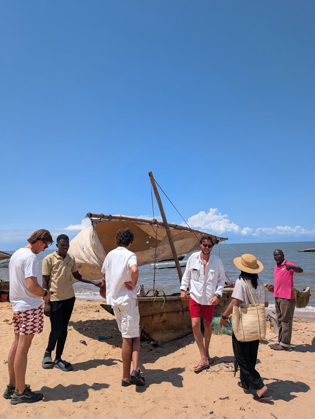 Huéspedes y la tripulación de Cterra junto a un dhow antes de zarpar