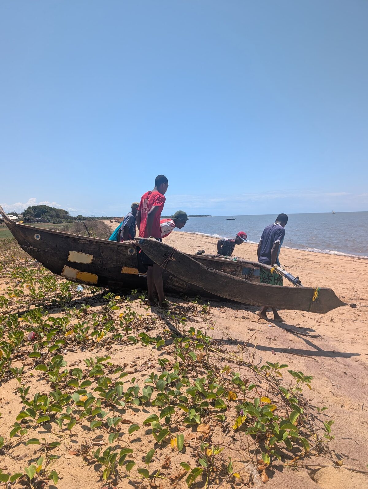 Pescadores del lugar preparando una canoa de balancín en la playa
