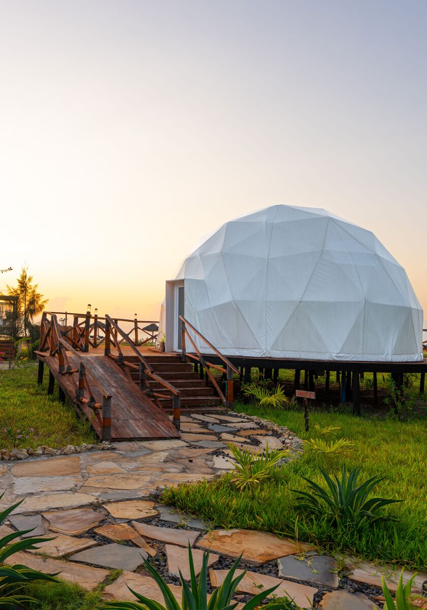 The domes from outside — The tented domes on their platforms, among the palms and facing the ocean.