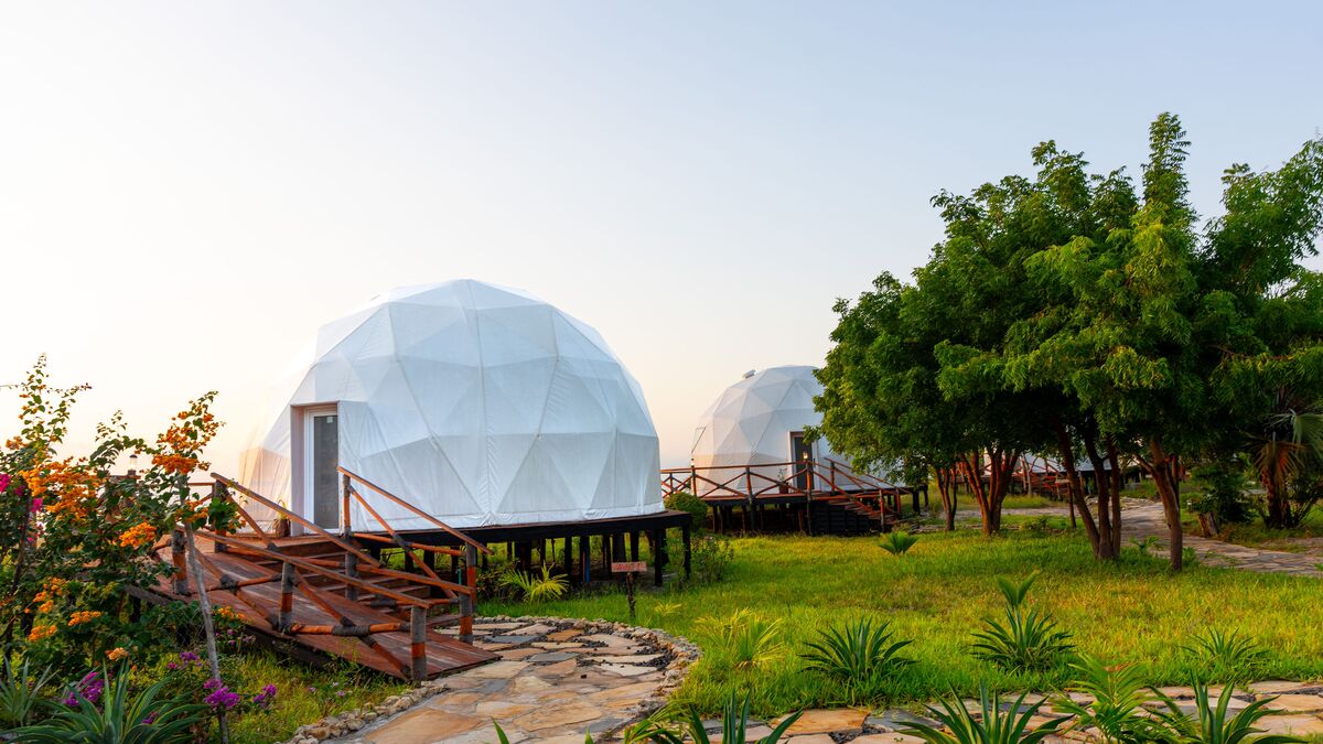 The domes from outside — The tented domes on their platforms, among the palms and facing the ocean.
