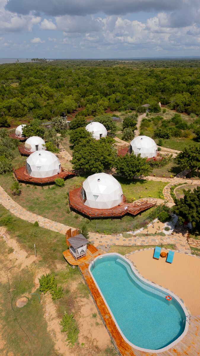 The domes from outside — The tented domes on their platforms, among the palms and facing the ocean.