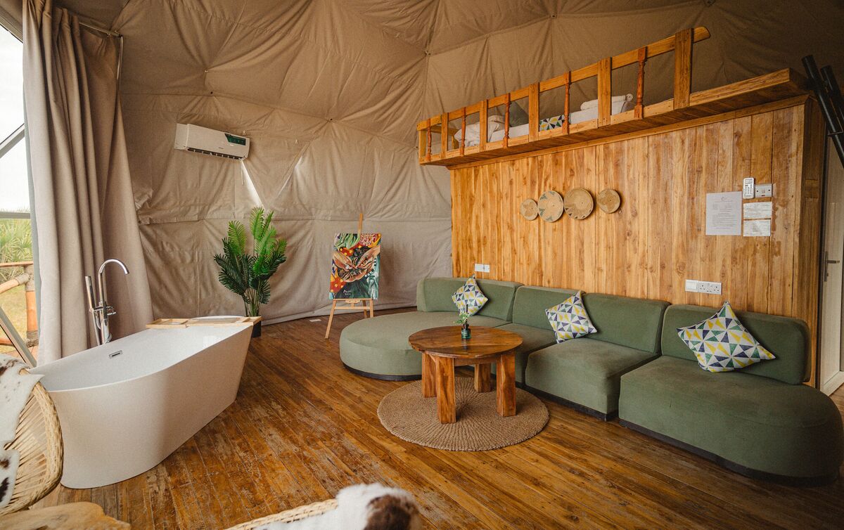 The Honey Suite at Cterra Saadani, with the green sofa and the freestanding bath