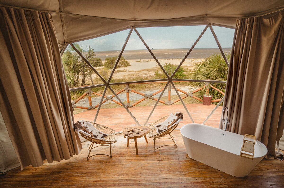 The freestanding bath of the Honey Suite, facing the glazed wall and the deck