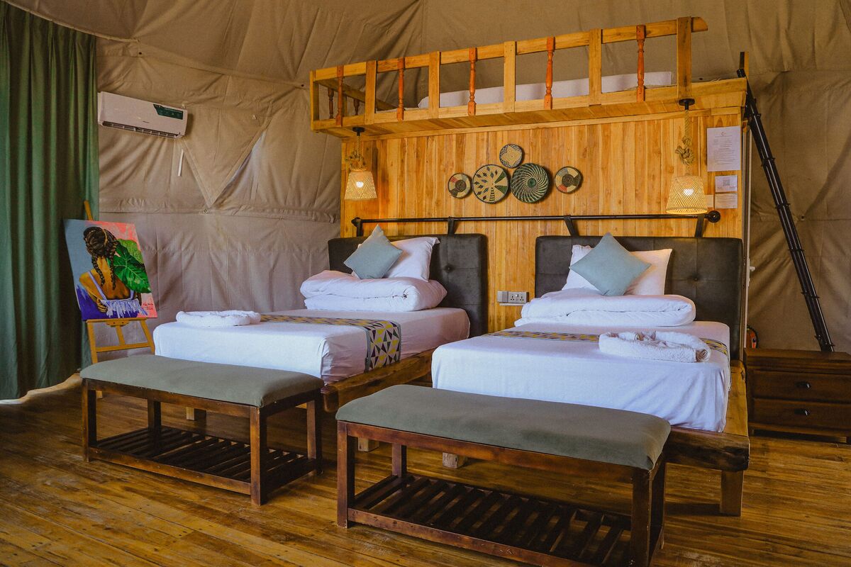 Inside the Twin dome at Cterra Saadani, with the separate beds and the woven plates on the timber wall