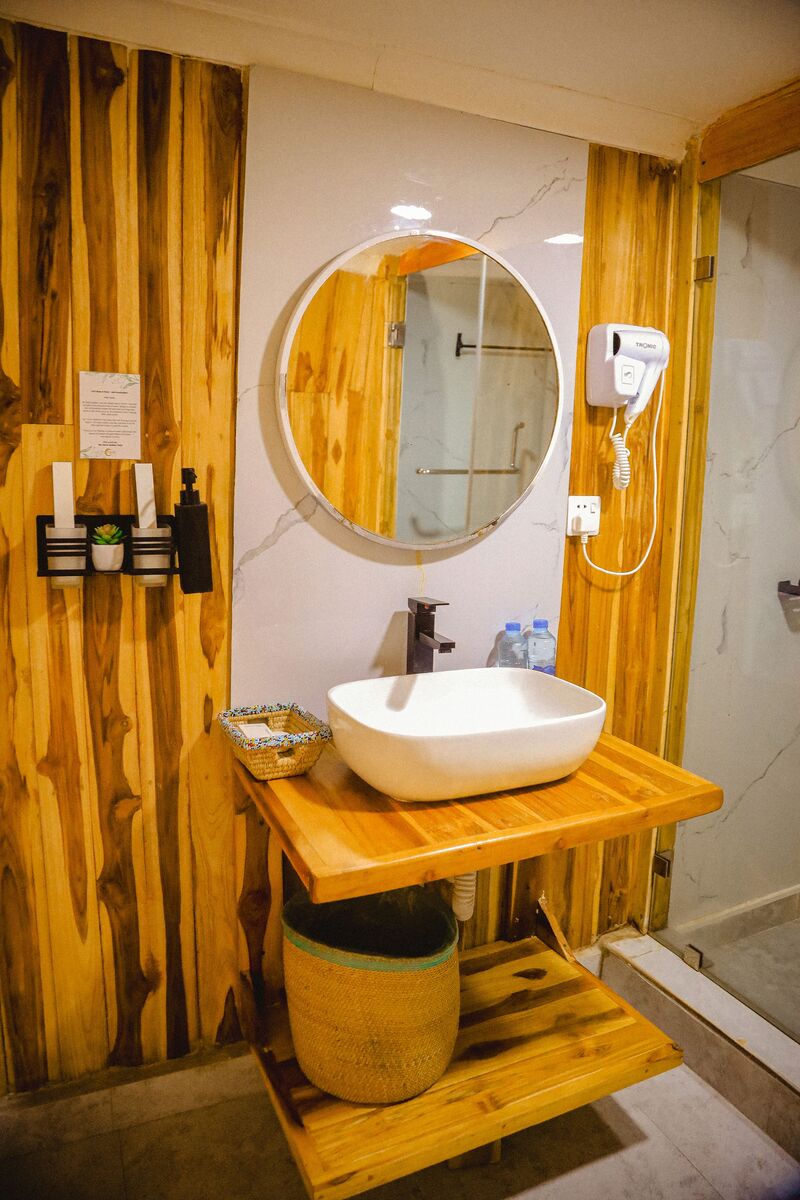 The walk-in shower in a dome bathroom, with the basin and the round mirror